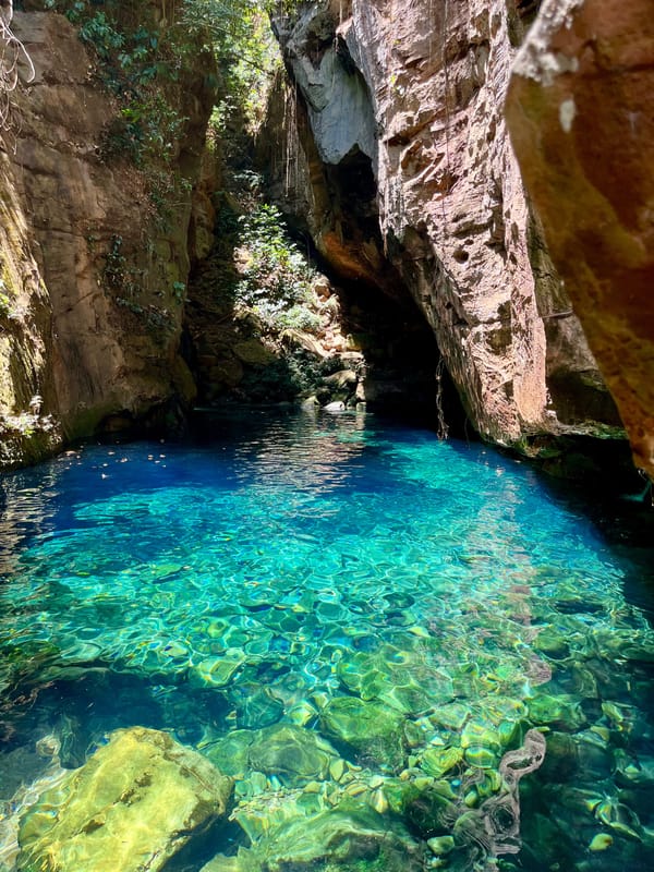 Poço de água turquesa transparente entre paredões de pedra