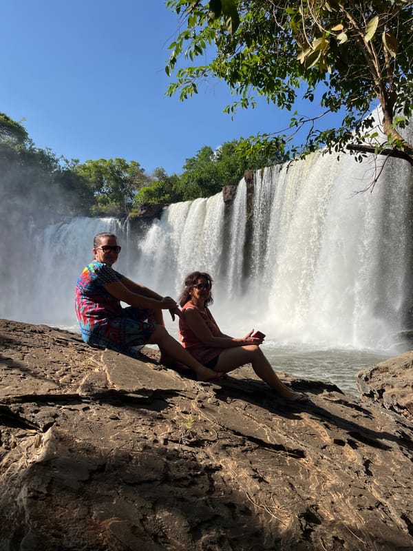 Casal sentado numa pedra diante da cachoeira larga do São Romão
