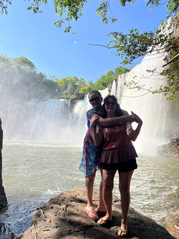 Duas mulheres abraçadas numa pedra diante da cachoeira do São Romão