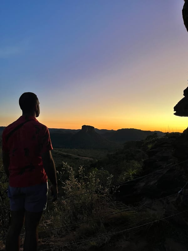 Silhueta de um homem olhando o fim do pôr do sol sobre as mesas, no Portal da Chapada