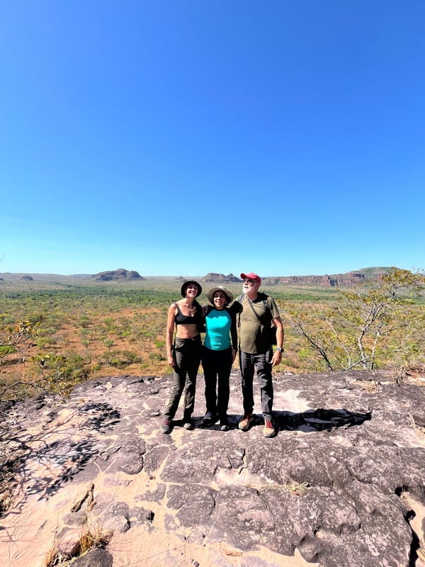 Três pessoas numa laje de pedra, com as mesas no horizonte
