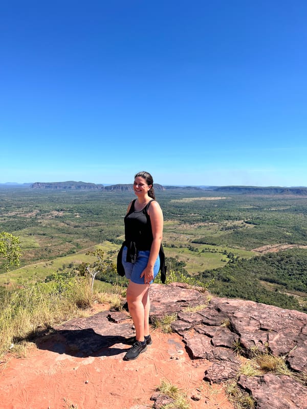 Mulher de pé numa pedra na borda do Morro do Chapéu, com o cerrado lá embaixo