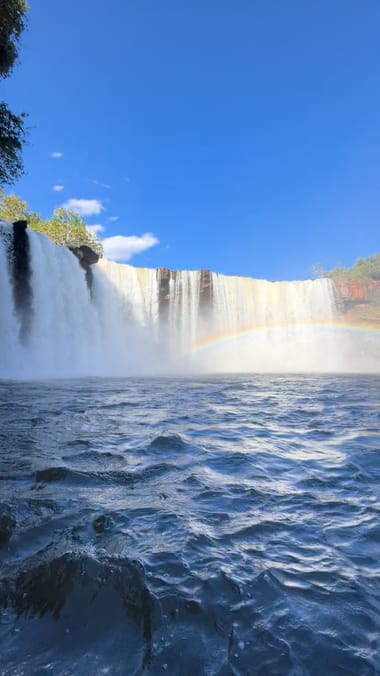 A cachoeira larga do São Romão caindo no rio, com um arco-íris na névoa