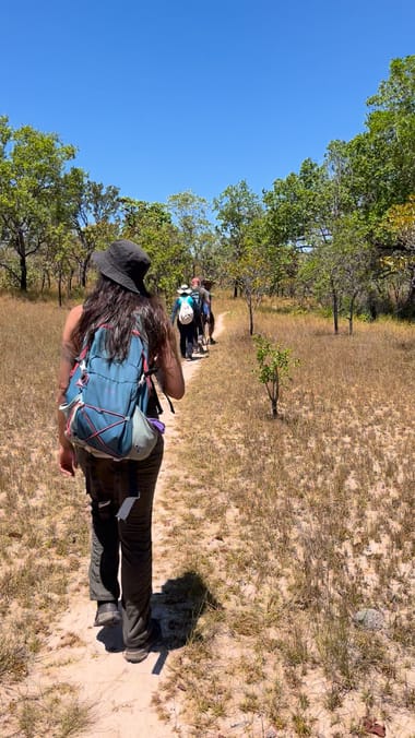 Caminhantes de mochila seguindo pela trilha no cerrado